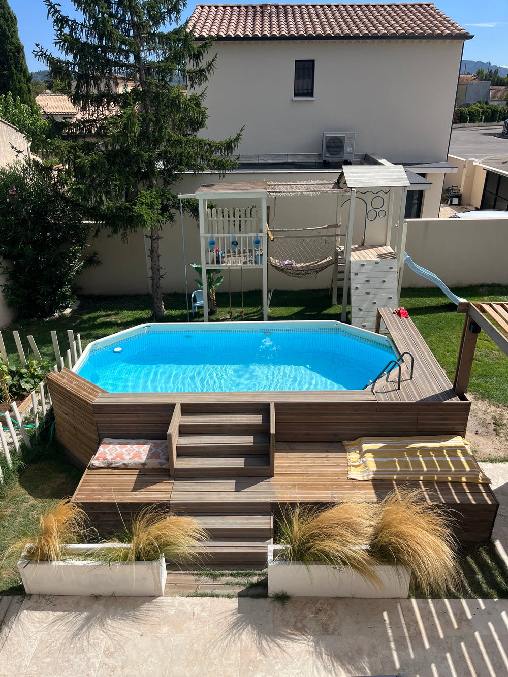 Habillage bois d'une piscine avec escalier et plage pour s'allonger