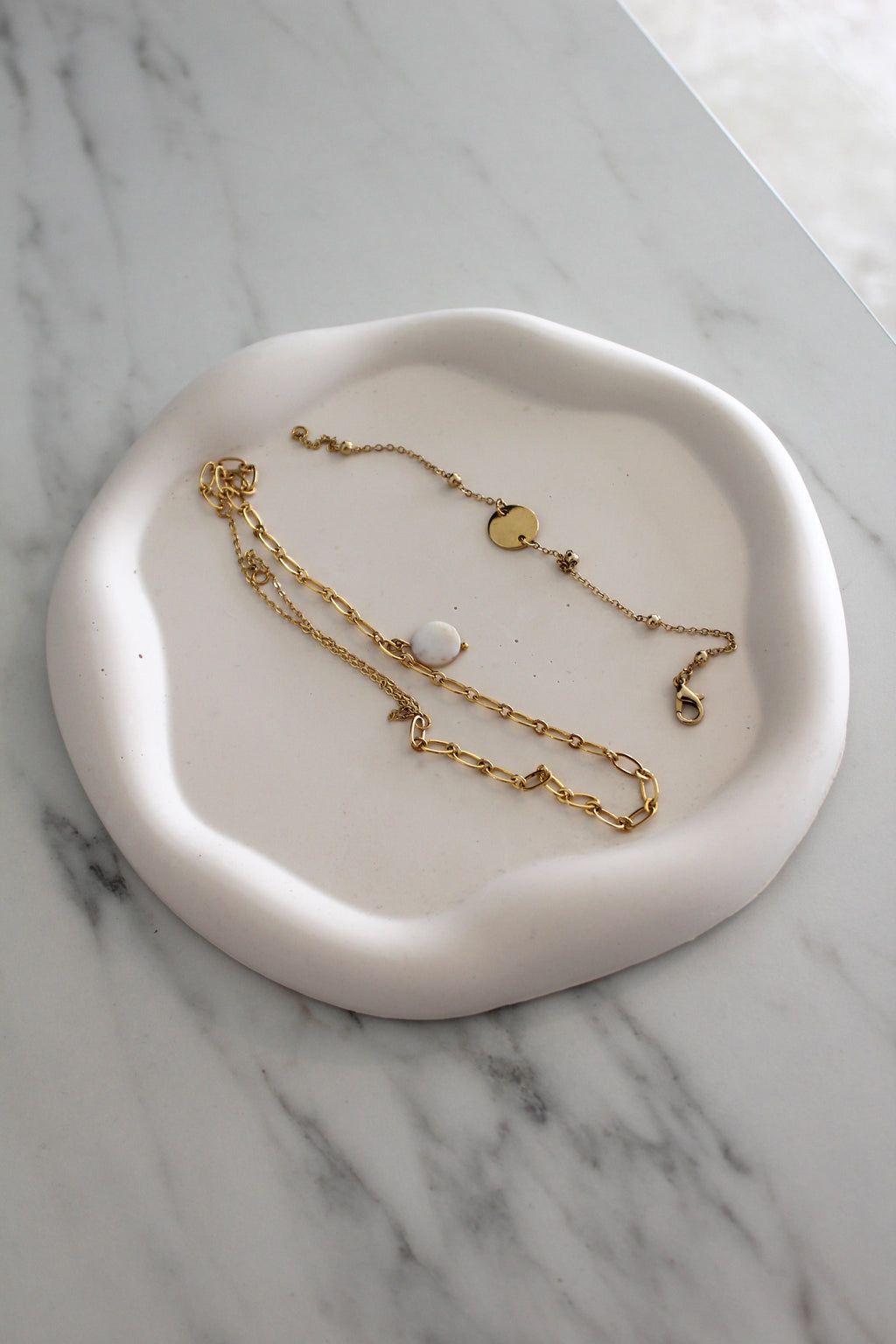 cloud tray en jesmonite avec es bijoux sur un comptoir en marbre creation artisanale e and f deco