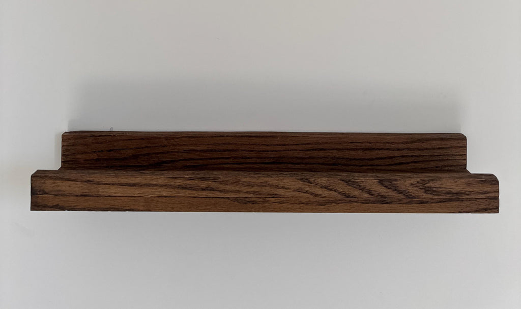 Détail d'une étagère à cadres en chêne avec rebord