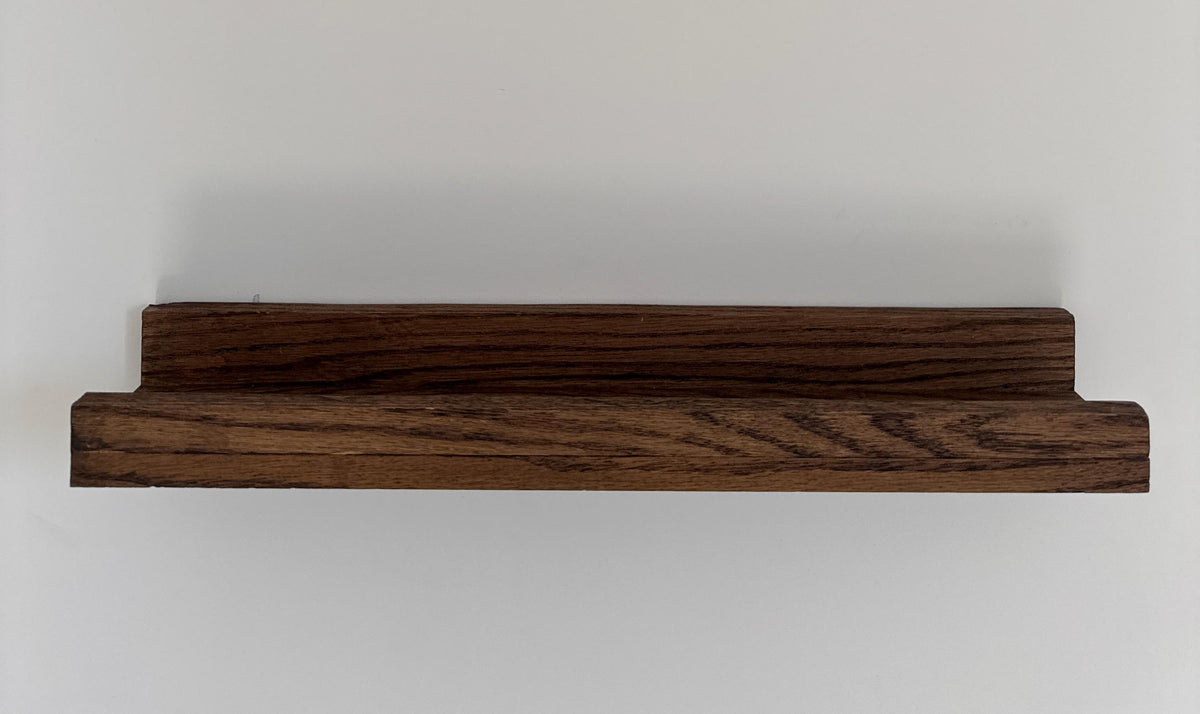 Détail d'une étagère à cadres en chêne avec rebord
