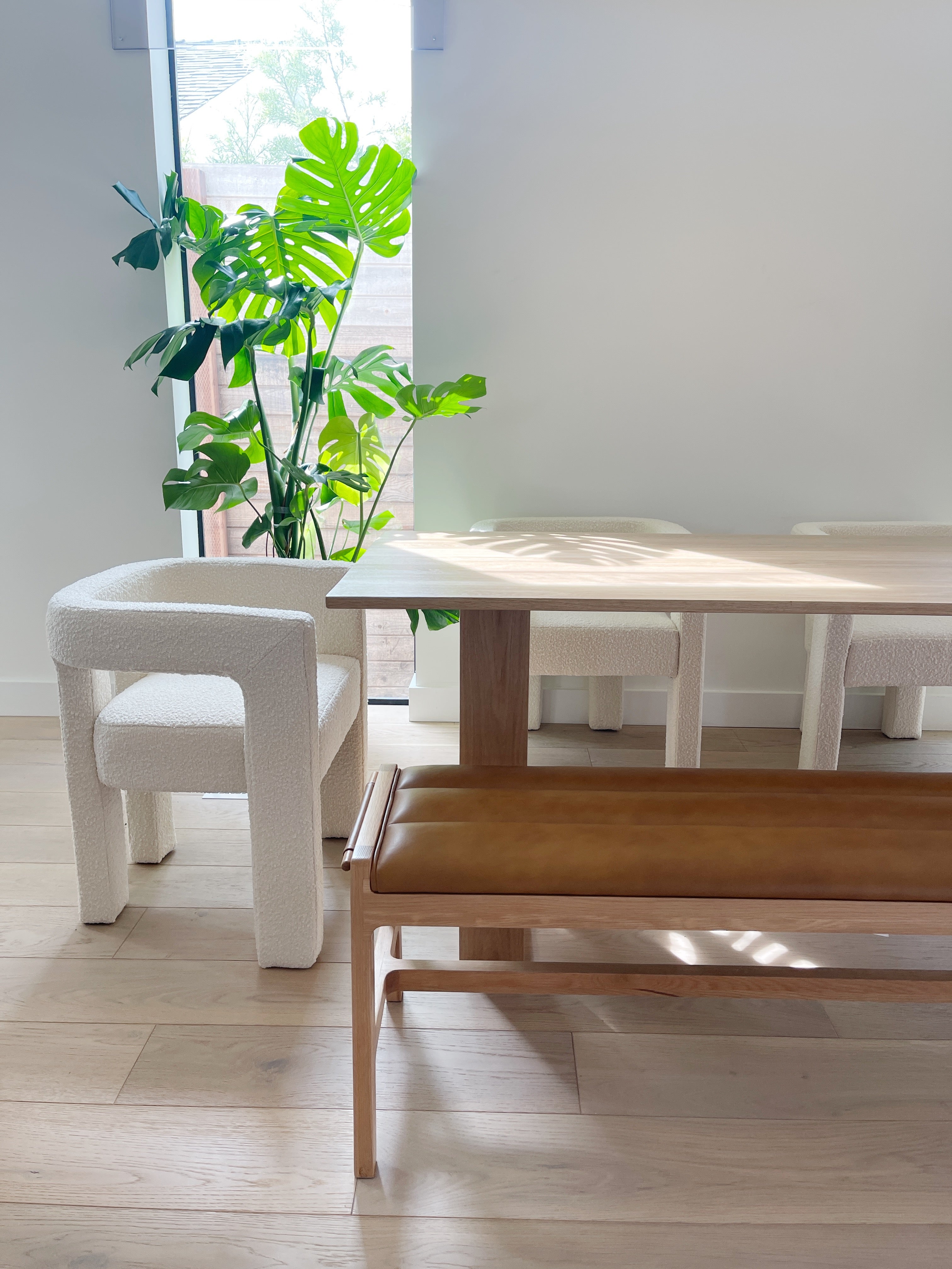 table a manger la Seattle en chene massif dans une maison a Los Angeles avec des chaises blanches et un banc en cuir design simple et minimaliste creation artisanale e f deco