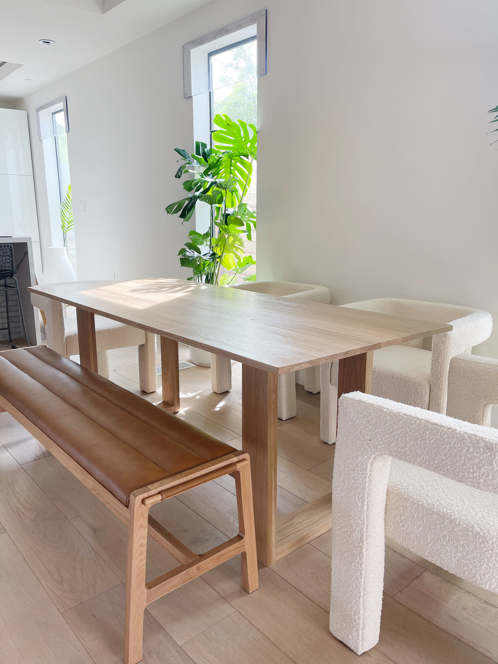 table a manger la Seattle en chene massif dans une maison a Los Angeles avec des chaises blanches et un banc en cuir design simple et minimaliste creation artisanale e f deco