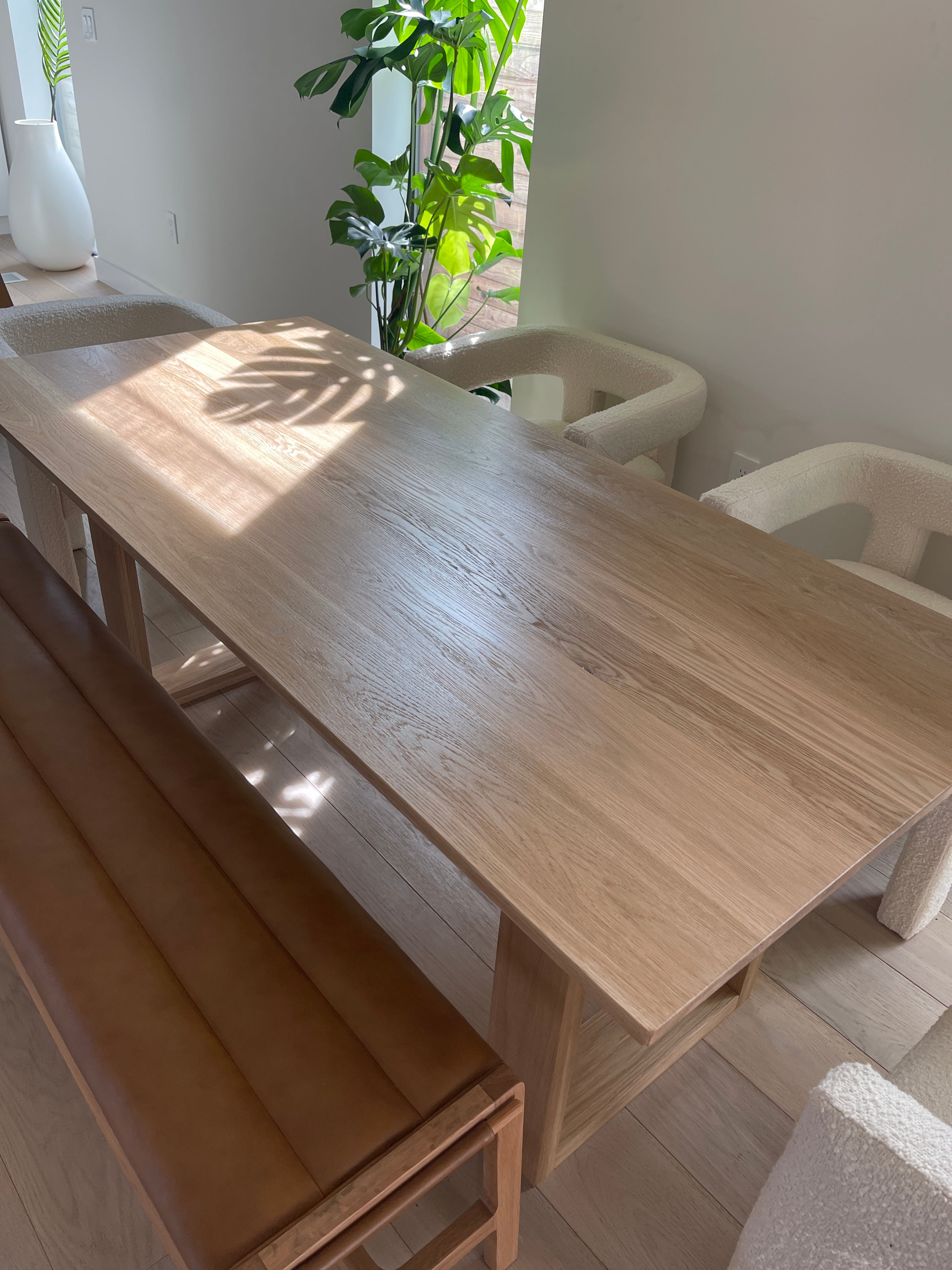 table a manger la Seattle en chene massif dans une maison a Los Angeles avec des chaises blanches et un banc en cuir design simple et minimaliste creation artisanale e f deco